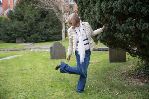 Lady checks her shoe worried she has stepped in dog poo